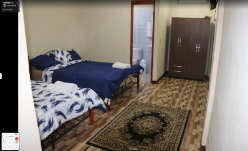 a bedroom with two beds with blue and white sheets at Hospedaje J.R in Chitré