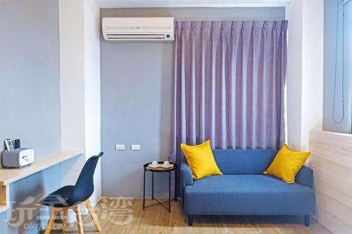 a living room with a blue couch and yellow pillows at S-Home in Huxi