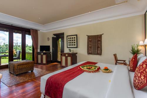 a bedroom with a large bed and a living room at Anhera Suite Ubud in Ubud