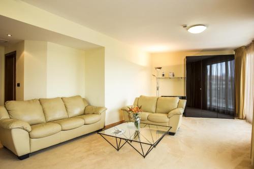 a living room with a couch and a glass table at Europe Hotel in Sofia