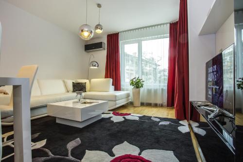 a living room with a white couch and red curtains at Europe Hotel in Sofia