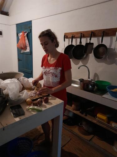 a woman standing in a kitchen preparing food at Agro Village Resort , Kalpitiya in Kalpitiya