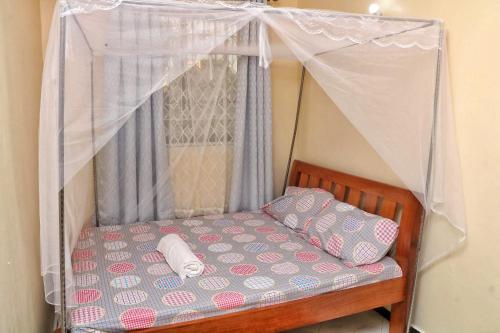 a bed with a canopy with two pillows on it at Nice Spacious 1bedroom hideout in bamburi in Mombasa