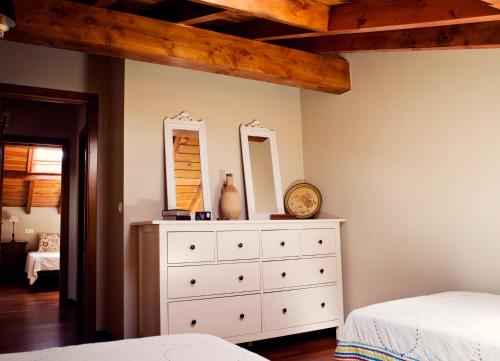 una camera da letto con cassettiera bianca e 2 specchi di Casa 4 Habitaciones en Osseja a Osséja