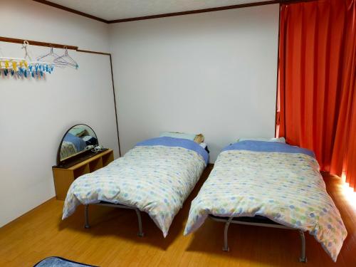 two beds sitting next to each other in a room at Shirahono Yado Aoi Umi in Ishigaki Island