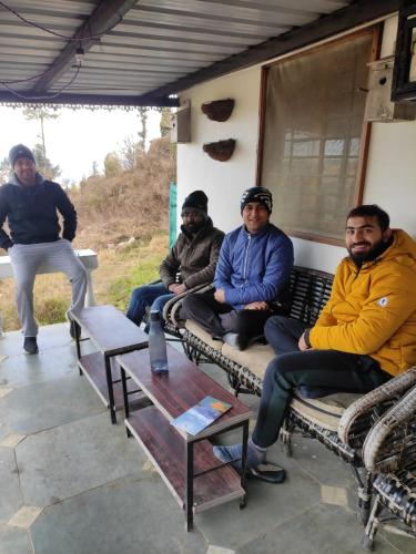 a group of men sitting on a bench at Dhanaulti Camp Homes Retreat in Dhanaulti