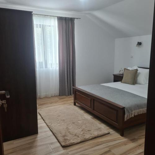 a bedroom with a bed and a large window at Casa Ardeluta in Ardeluţa