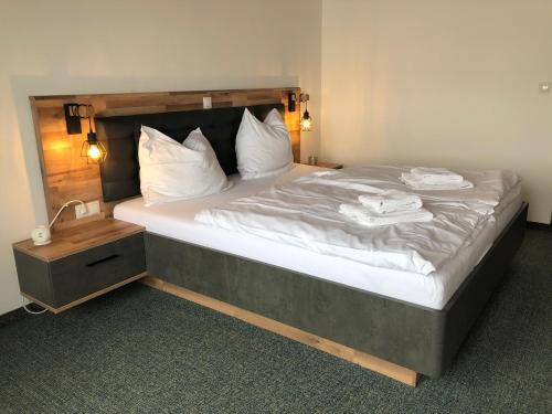 a large bed with white sheets and pillows on it at Sportpension Therese in Westendorf