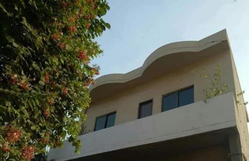 a building with a ivy covered hedge next to it at Family Guest House Lahore Near Airport in Lahore