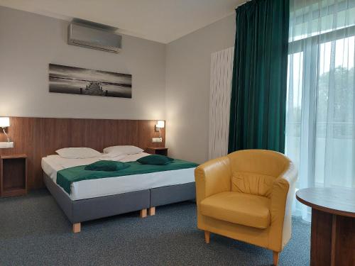 um quarto com uma cama e uma cadeira em Eurohotel em Baniocha