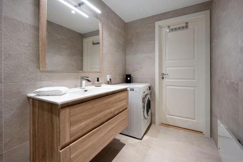 a bathroom with a sink and a washing machine at Homelike and Cozy Apt close to City Centre in Stavanger