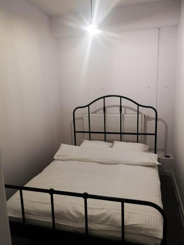 a bed in a white room with a light on it at Apartamenty LENA 4 in Racibórz