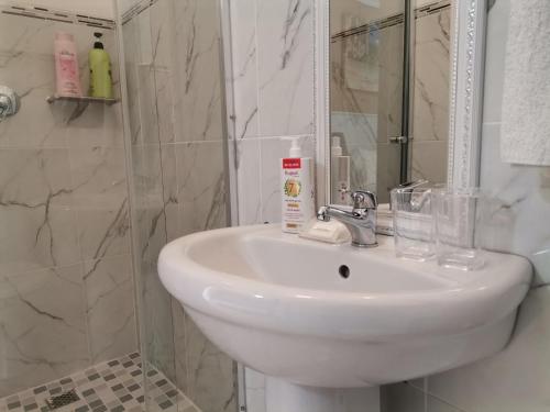 a bathroom with a white sink and a shower at Onyx on Sycamore in Cape Town