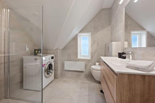 a bathroom with a washing machine and a sink at Unique and Spacious Apt close to City Centre in Stavanger