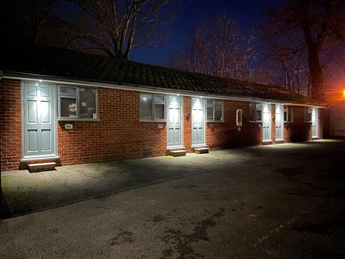 a brick building with white doors at night at Arlan House, Central Basingstoke Hotel in Basingstoke