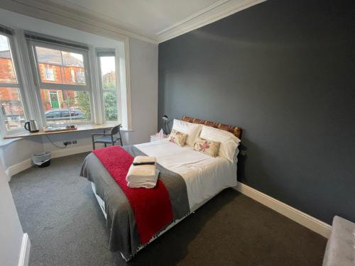 a bedroom with a bed with a red blanket at Arlan House, Central Basingstoke Hotel in Basingstoke