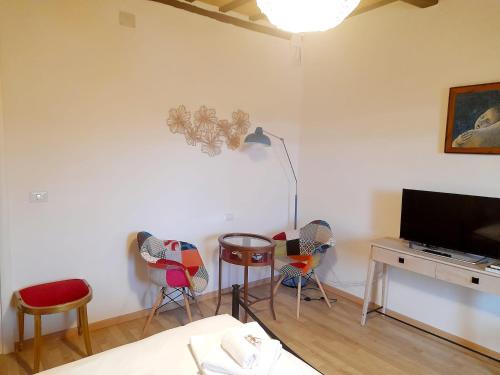 a living room with chairs and a flat screen tv at Appartamento Palma in Spello