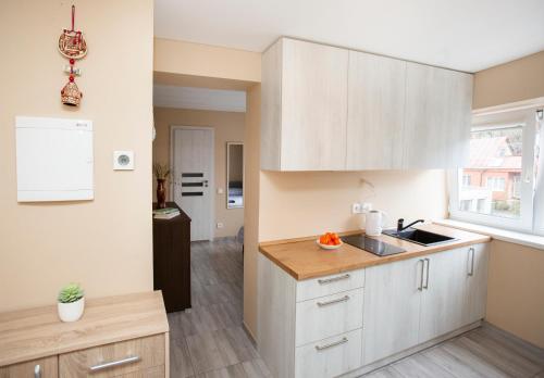 une cuisine avec des armoires blanches et un évier dans l'établissement Chill&Go Apartment, à Kaunas