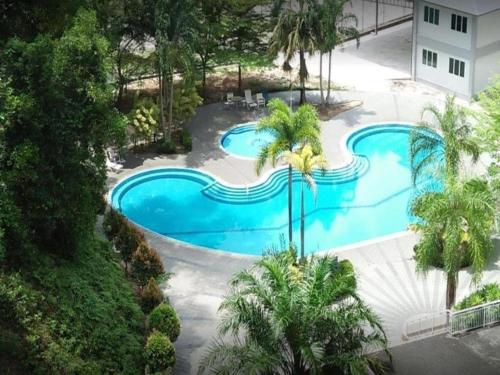 uma vista sobre uma piscina com palmeiras em Lumut Valley Condominium em Lumut