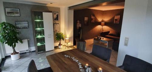 a living room with a wooden table and a dining room at Ferienwohnung Flensfjord in Wees