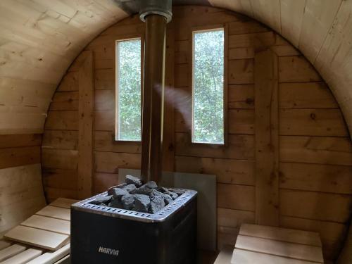 a room with a woodburning stove in a cabin at Suite Petite -Nice - SPA-JACUZZI - MASSAGE- SAUNA - 4 SAISONS - Piscine Chauffée Toute l'année - POOL VIEW- Heated Pool 800m city centre Nyons in Nyons