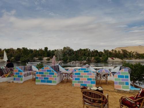een groep tafels en stoelen op een strand bij Baba Dool in Aswan