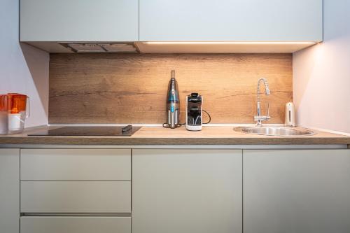 a kitchen with white cabinets and a sink at Kron luxury 2 Bedroom Apartment in Silver Mountain in Poiana Brasov