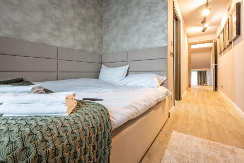 a bedroom with a large bed and a hallway at Kron luxury 2 Bedroom Apartment in Silver Mountain in Poiana Brasov