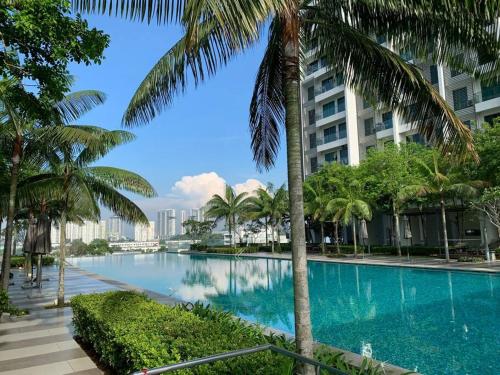 サイバージャヤにあるRomantic Couples Relaxing Staycation 8のヤシの木が立ち並ぶ建物の前のスイミングプール
