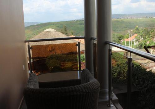 a balcony with a chair and a view of a field at The Little Hill Boutique Hotel in Kigali