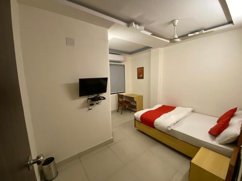 a bedroom with a bed and a tv in it at Hotel Riverfront in Ahmedabad