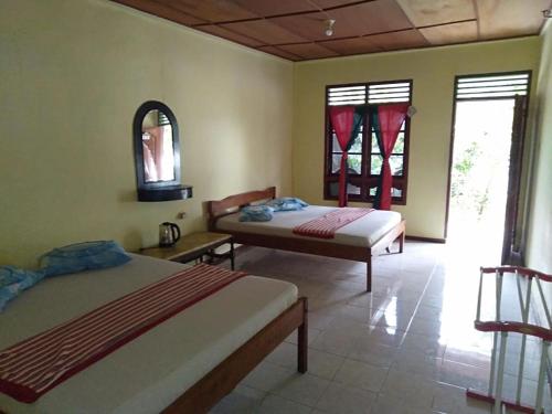 a bedroom with two beds and two windows at Sibayak Guesthouse in Tuk Tuk