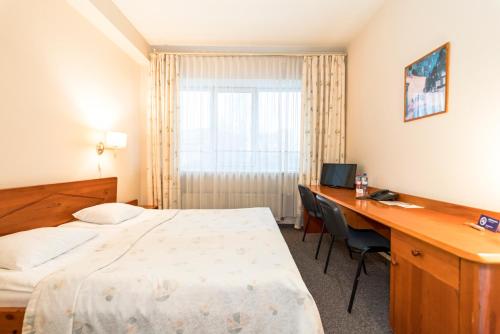 a hotel room with a bed and a desk at Kolonna Hotel Brigita in Rīga