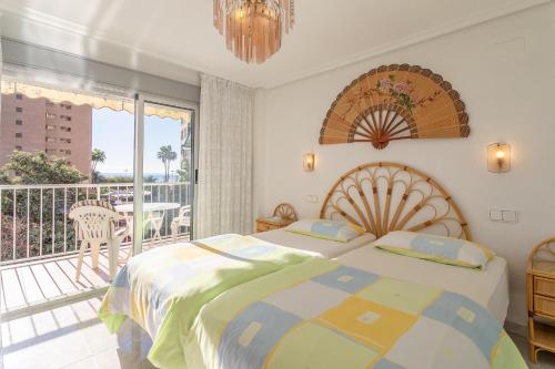 a bedroom with a bed and a balcony at Aparmento Eolo in Benidorm