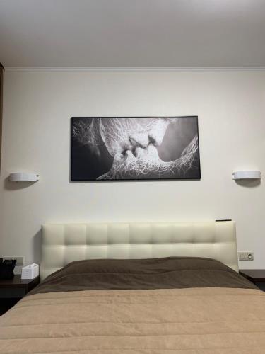 a bedroom with a bed with a picture on the wall at Петрівський in Kropyvnytskyi