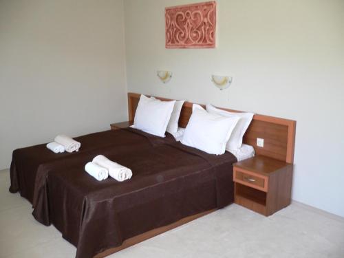 a bedroom with a bed with two towels on it at Madara Club and Spa in Kosharitsa