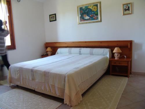 a bedroom with a bed and two lamps on tables at Il Gabbiano in Chia