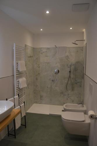 a bathroom with a shower and a toilet and a sink at Hotel Cova in Pellizzano