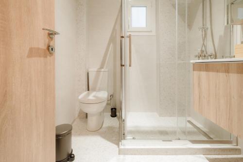 a bathroom with a toilet and a glass shower at Urban Jasmine in Thessaloniki