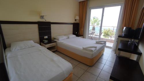 a hotel room with two beds and a window at Kleopatra Balik Hotel in Alanya