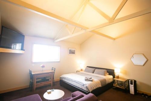 a bedroom with a bed and a tv and a table at 3 Hills at The Good Place in Staverton