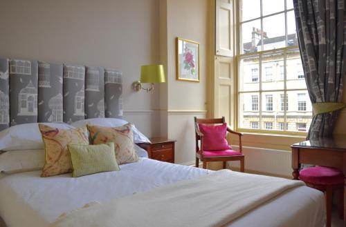 ein Schlafzimmer mit einem weißen Bett und einem Fenster in der Unterkunft The Windsor Town House in Bath