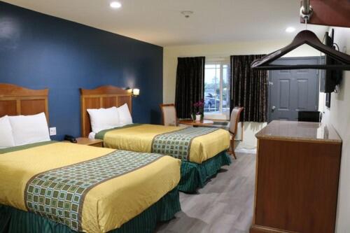 a hotel room with two beds and a desk at Valli Hi Motel in San Ysidro, San Diego
