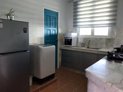 a kitchen with a refrigerator and a blue door at Blue Andaman Seaview Families Suite Apartment in Kuah