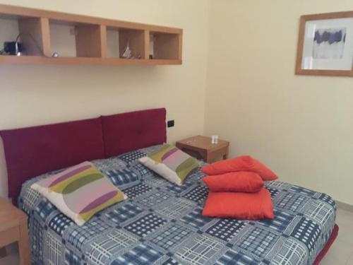 una camera da letto con un letto con cuscini rossi di L alloggio perfetto Garden a Castellana Grotte