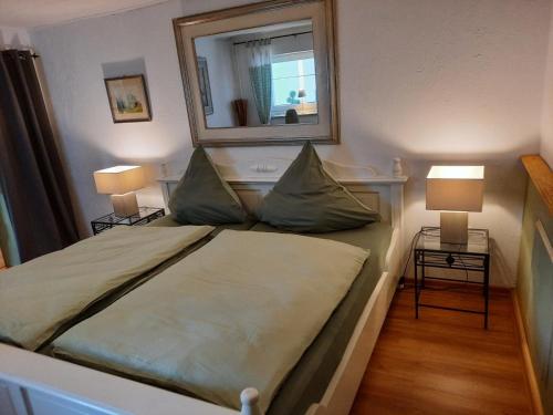 um quarto com uma cama com um espelho e 2 candeeiros em Ferienwohnung "Wiesensee" im historischen Landhaus em Pottum