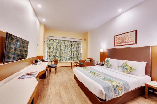 a hotel room with a large bed and a window at E Square The Fern, Pune in Pune