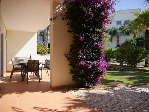 a house with purple flowers on the side of it at Spacious Apartment near Porto de Mos Beach, Lagos. in Lagos