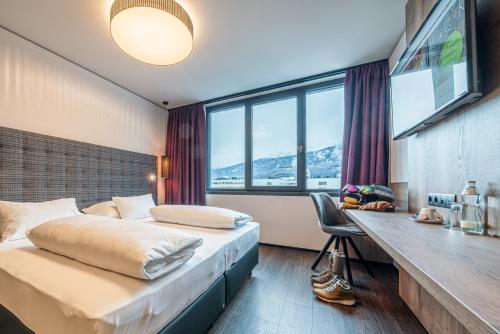 um quarto de hotel com duas camas e uma secretária em Rufi's Hotel Innsbruck em Innsbruck