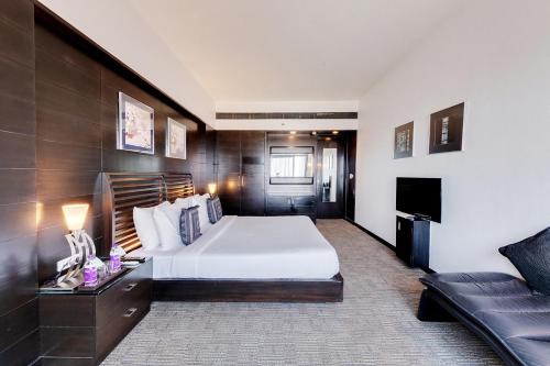 a hotel room with a bed and a couch at E Square The Fern, Pune in Pune